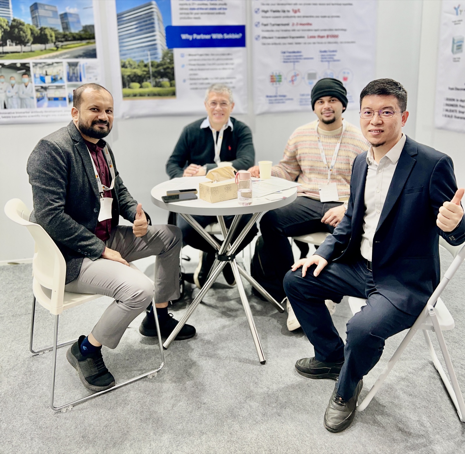 Sekbio team and international IVD partners celebrating a successful meeting at the Medica 2025 booth with thumbs up