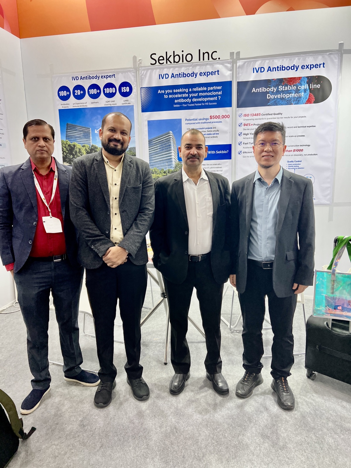 Sekbio team group photo with global IVD clients in front of Sekbio Inc. exhibition banners at Medica 2025